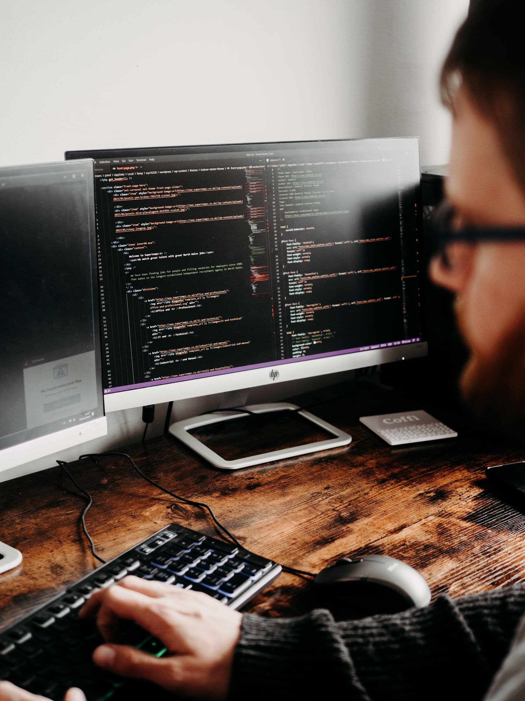 Ingeniero desarrollando software frente a varios monitores